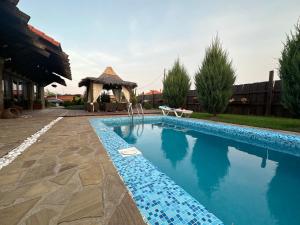 敖德萨Chervona Kalyna Cottage的一个带凉亭的庭院内的游泳池