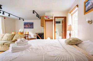 沃尔卡诺Halema'uma'u- Hale Kumu La'au的卧室配有一张白色的大床和一张沙发。