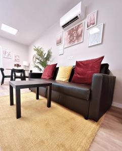 戈梅拉岛圣塞瓦斯蒂安Apartamentos Pepita的客厅配有黑色沙发和桌子