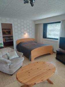 PirkkalaLakeside Villa Lehtiniemi的一间卧室配有一张床、一张沙发和一张桌子