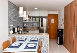 普拉亚多斯卡内罗斯Carneiros Beach Resort Flat Térreo 2 quartos的厨房配有桌子和冰箱