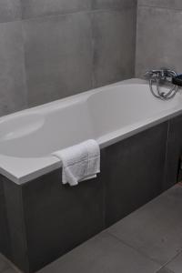 哈博罗内Square Connexions Guest House的带浴缸和毛巾的浴室