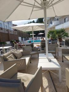 卡拉古诺内尼图诺酒店的带沙发和遮阳伞的天井以及游泳池。