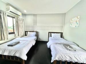 程逸府J2 INN的客房设有2张带白色床单的床和窗户。