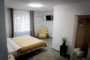 穆里吉奥尔Pescarul Deltei的一间卧室配有一张床和一张黄色椅子