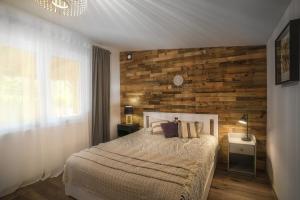 SławicaSławica Inn domek letniskowy nad jeziorem的一间卧室设有一张床和木墙