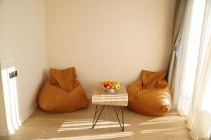 巴统RUMI Hotel的一间房间,配有两把橙色椅子和一张桌子及一碗水果