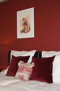 赫尔B&B Hooglandhoeve的一间卧室设有红色的墙壁和一张带红色枕头的床