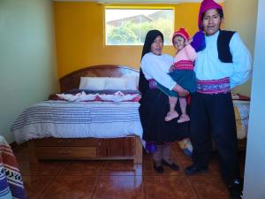 HuillanopampaTaquile Inti Raymi Lodge的一群人站在床边