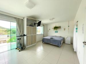 塞尔苏拉穆斯州长镇Ipê Palmas Hostel的一间卧室设有一张床和一个大窗户