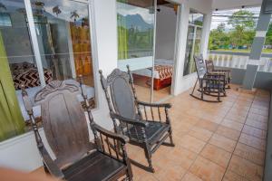 福尔图纳Hotel Sierra Arenal的门廊上设有摇椅的房间
