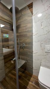 地拉那Vila 90 Boutique Hotel的浴室设有玻璃淋浴间和卫生间
