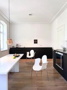 科隆Zehuus mit Domblick und Dachterrasse的厨房配有白色的椅子和白色的台面