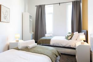 斯旺西The Kingsway- 2 Bedroom Central Swansea Apartments By StayRight的一间卧室设有两张床和窗户。