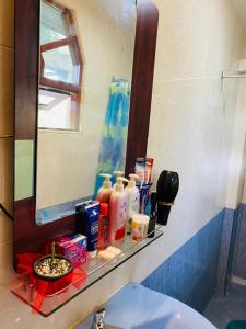 卡图纳耶克ANTONIO TRANSIT KATUNAYAKE的浴室盥洗盆配有镜子、架子和洗浴用品