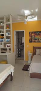 库尼亚Hospedagem Quarto Chic centro Cunha的一间卧室设有两张床和黄色的墙壁
