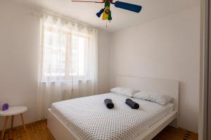 科佩尔Villa Andrea的白色卧室配有一张带吊扇的床