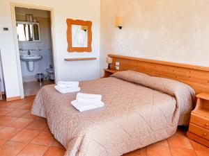 阿夏戈Hotel Ristorante La Baitina的一间卧室配有一张床,上面有两条毛巾