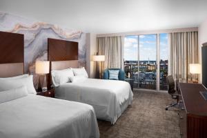 萨凡纳The Westin Savannah Harbor Golf Resort & Spa的酒店客房配有两张床和一张书桌