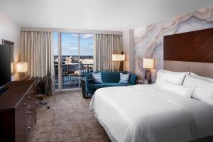 萨凡纳The Westin Savannah Harbor Golf Resort & Spa的酒店客房设有一张大床和一张沙发。