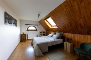 雅莱L'Ermitage的一间卧室配有一张带木墙和窗户的床。