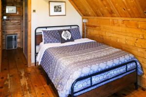 摩押Sunny Acres Cabin的木制客房内的一间卧室,配有一张床