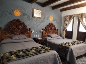 圣克里斯托瓦尔-德拉斯卡萨斯格兰德玛丽亚酒店的一间卧室设有两张床和两个窗户。