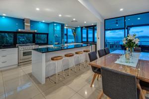汉密尔顿岛Edge 16 Waterfront Luxury Property - Golf Buggy & Valet Service的厨房配有蓝色橱柜和桌椅