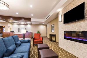 PiedmontComfort Suites Greenville South的客厅配有蓝色的沙发和平面电视。