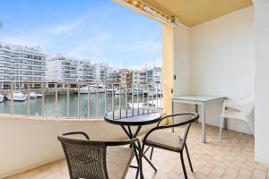 艾姆布里亚布拉瓦Apartamento WELCS EMP 093 con vistas al Canal的阳台配有桌椅,享有海港的景致。