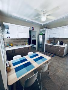 卡沃罗霍2-BR Modern Oceanfront Apt Steps from Playa Sucia的厨房配有桌椅和冰箱。