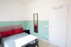 佩罗Maison SINDBAD的一间卧室配有一张带红色枕头和镜子的床