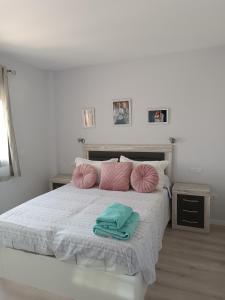 穆尔西亚Apartamento Holydais Monica的一间卧室配有带粉色和绿色枕头的床