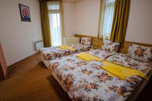 潘波洛沃Pamporovo Cottage Savov的配有黄色床单的酒店客房的两张床