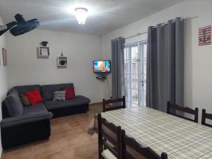 瓜拉图巴Casa Aconchego - piscina com hidromassagem的客厅配有沙发和桌子