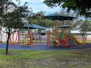 迈阿密Wynwood Beds的公园内一个带色彩缤纷的滑梯和遮阳伞的游乐场