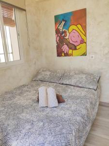 格拉纳达Lolas Cozy Studio的一张带两个枕头的床和墙上的绘画