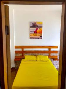 洛佩斯港COLIBRI GUEST HOUSE的一间卧室,卧室内设有一张黄色的大床