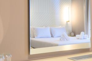 卡拉马塔BlueBlood - The Rooms的一间卧室配有一张带白色枕头和镜子的床