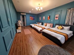 Trà VinhBich Ngoan HOTEL的配有蓝色墙壁和木地板的客房中的两张床