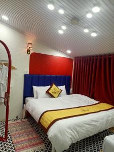 Trà VinhBich Ngoan HOTEL的一间卧室配有一张红色和蓝色床头板的床