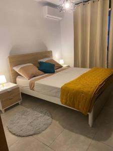 Rémire-CampLe petit colibri的一间卧室配有一张带黄色毯子的大床