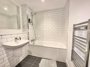 曼彻斯特Morden 2 Bed Apartment - Manchester Old Trafford的白色的浴室设有水槽和浴缸。