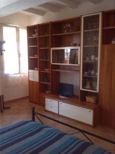 里奥马里纳Appartamenti Claudia Rio的一间卧室配有木制橱柜和一张床