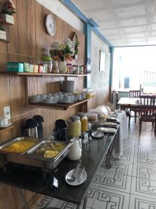 伊塔帕里卡Pousada Ponta de Areia的厨房提供自助餐,餐桌上供应食物
