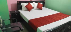 DānāpurSPOT ON Hotel Royal Garden的一间卧室配有红色和白色枕头的床
