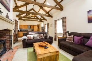 阿尼克Birsley Cottage的客厅配有皮革家具和壁炉