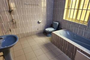 CococodjiMaison Verte a Cococodji的浴室配有卫生间、浴缸和水槽。