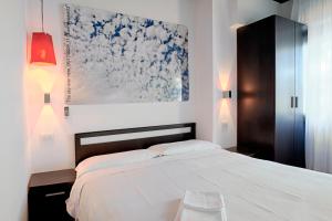 圣马力诺西尔瓦娜酒店的卧室配有一张床,墙上挂有绘画作品