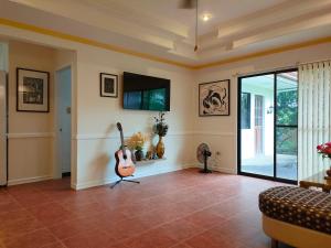 邦劳DMC2 Residence Panglao的客厅配有吉他和电视